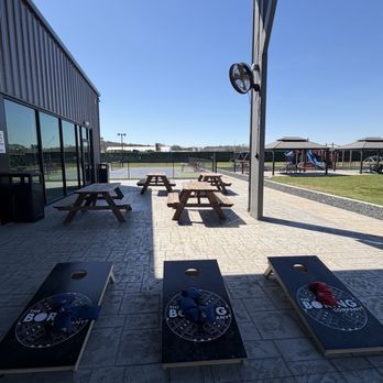 Patio picnic tables and cornhole boards